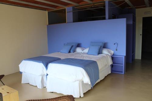 1 dormitorio con 2 camas y pared azul en Mas Ravetllat, en Isóbol
