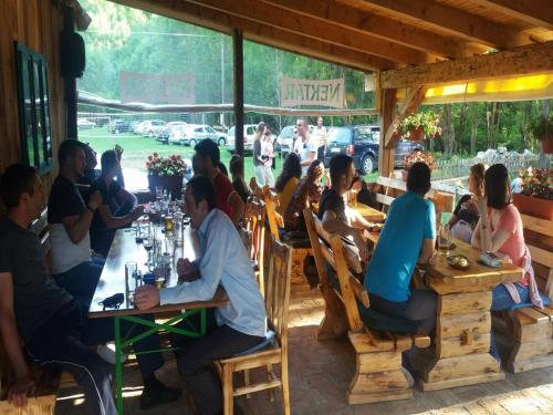 a group of people sitting at tables in a restaurant at Seoski turizam Ziličina Rogatica in Rogatica