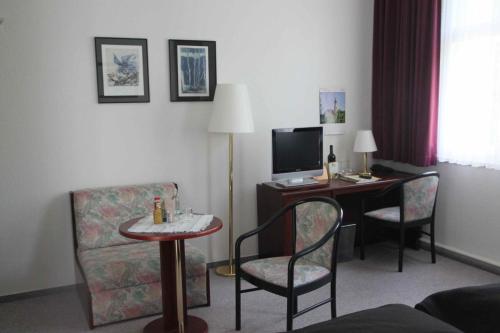 a hotel room with a desk with a computer and chairs at Stadt-Gut-Hotels - Das Kleine Hotel in Weimar