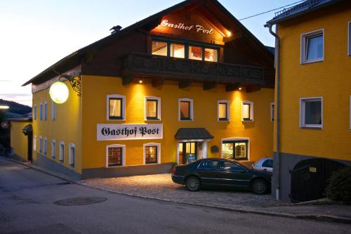 a car parked in front of a yellow building at Gasthof Post in Peilstein im Mühlviertel