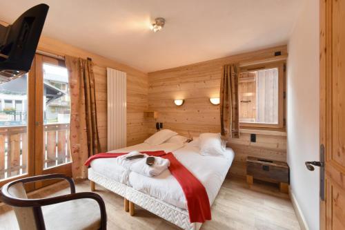 a bedroom with a bed with a dog laying on it at Loc'Hotel Alpen Sports in Les Gets