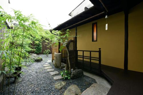 a small house with a fence and a walkway at Kuraya Senbonsanjo in Kyoto