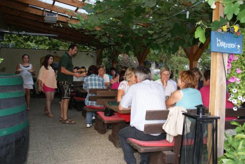 a group of people sitting at tables in a restaurant at Weingut Lieschnegg in Leutschach
