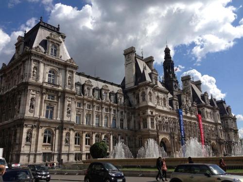 a large building with a fountain in front of it at Hotel de la Bretonnerie in Paris