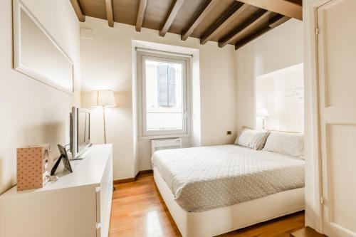 a white bedroom with a bed and a window at Navona Bernini Lodge in Rome