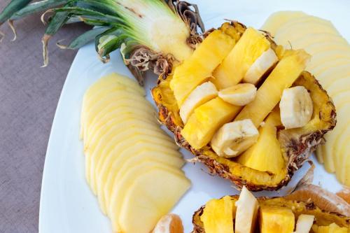 un piatto bianco con un ananas tagliato a metà di Dimitra & Evdokia Hotel ad Agia Marina Nea Kydonias