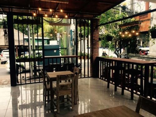 a restaurant with a table and chairs and windows at Sari Room Bed & Breakfast in Nusa Dua