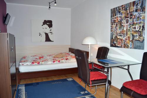 a bedroom with a bed and a desk and a table at Willa Allegra in Międzyzdroje