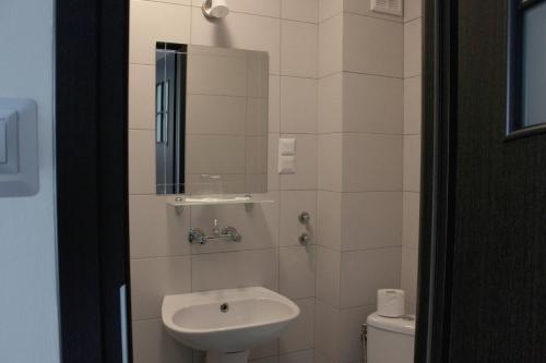 a bathroom with a sink and a toilet at Hotel City in Koszalin