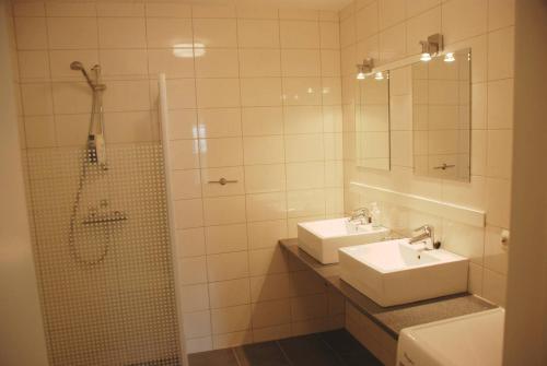 a bathroom with two sinks and a shower and a mirror at Apartment - Lille Galleri - Fyresdal in Fyresdal
