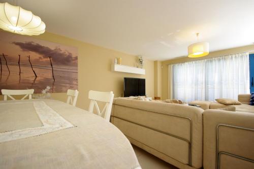 タリファにあるLivingtarifa Apartamento La Islaのベッドルーム1室(ベッド1台付)、リビングルーム(ソファ付)