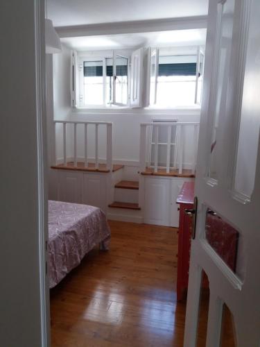 a small room with a bed and two windows at Casa dos Azulejos in Lisbon