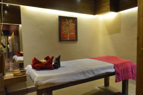 Habitación con cama con almohadas rojas. en Hotel Mount Regency by SAH, en Mount Abu