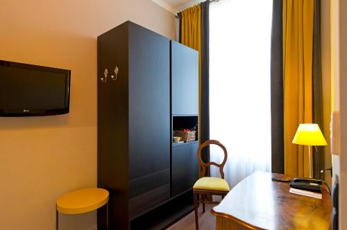 a room with a desk and a cabinet with a tv at Hotel Beethoven Wien in Vienna