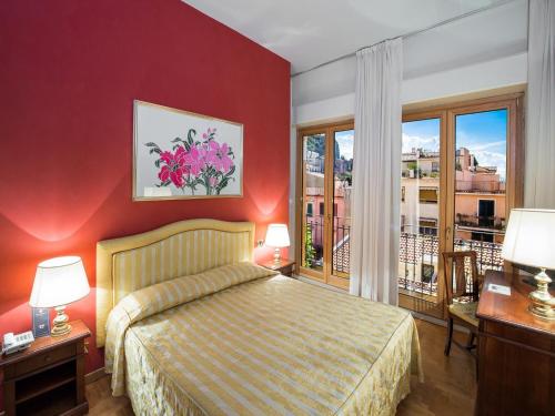 a hotel room with a bed and a balcony at Hotel Isabella in Taormina