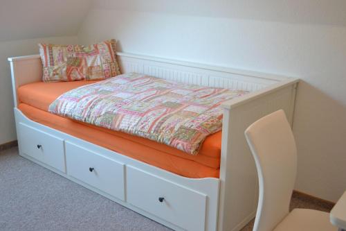 タツィングにあるRochelsand-App-3-OGの白いベッド(オレンジ色のマットレス、椅子付)