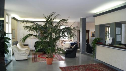 a living room with a palm tree in the middle at Hotel Ristorante Novara Expo in Bareggio