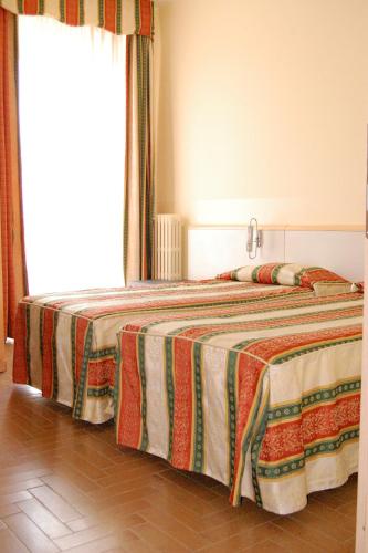 a bedroom with a bed with a blanket on it at Hotel Ristorante Novara Expo in Bareggio