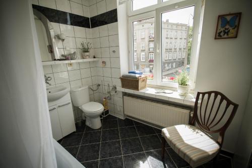 a bathroom with a toilet and a sink and a window at Przyjazne mieszkanie na Starym Miescie in Gniezno