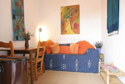 sala de estar con sofá azul y almohadas de color naranja en Casas Karen, en Los Caños de Meca