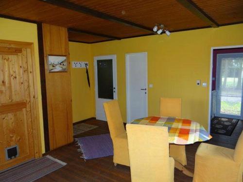 ein Wohnzimmer mit einem Tisch und Stühlen sowie ein Esszimmer in der Unterkunft Ferienhaus Thom in Neubäu am See in Neubäu
