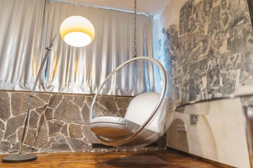 einen Schaukelstuhl in einem Zimmer mit einer Lampe in der Unterkunft 18Arts Hotel - Living in a Gallery! in Köln