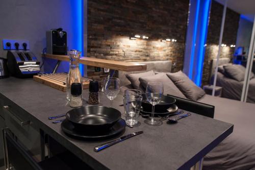 a kitchen counter with a table with plates and wine glasses at Cocoon'Inn Toulouse in Toulouse