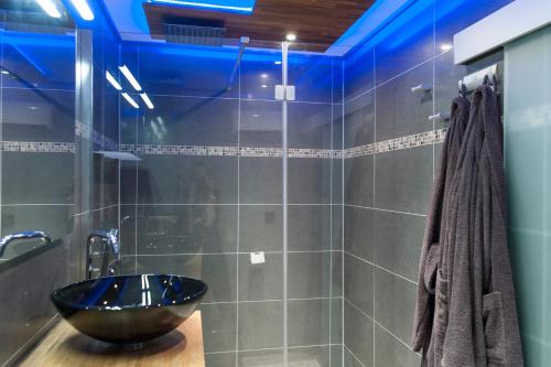 La salle de bains est pourvue d'un lavabo et d'un éclairage bleu. dans l'établissement Cocoon'Inn Toulouse, à Toulouse