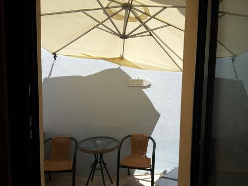 a table and two chairs and an umbrella at Frourio Apartments in Chios