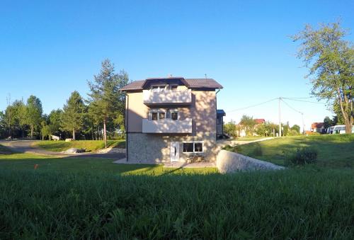 a small stone house in a field of grass at Black Queen Guesthouse in Grabovac