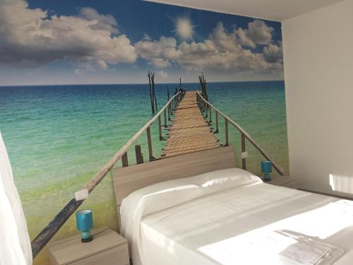 a bedroom with a mural of a boardwalk to the ocean at Diana's in Stintino