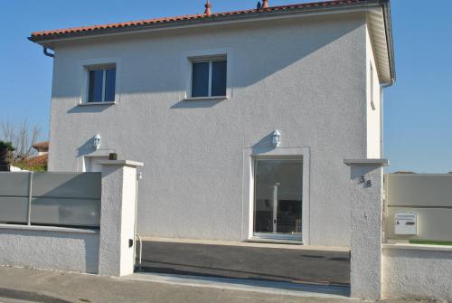 a white house with a window on the side of it at La Marina in Chassieu