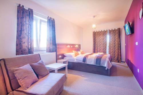 a hotel room with a bed and a couch at Black Queen Guesthouse in Grabovac