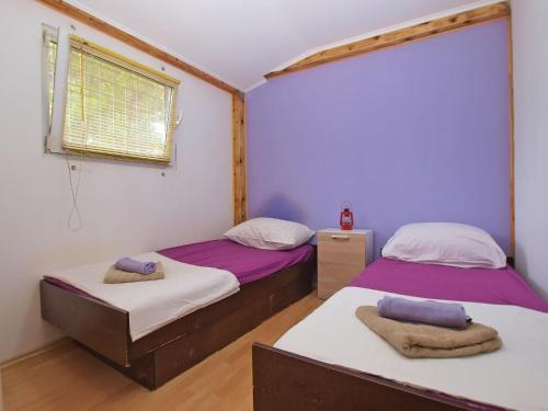 two beds in a room with purple and white walls at House Nikola 1422 in Peroj