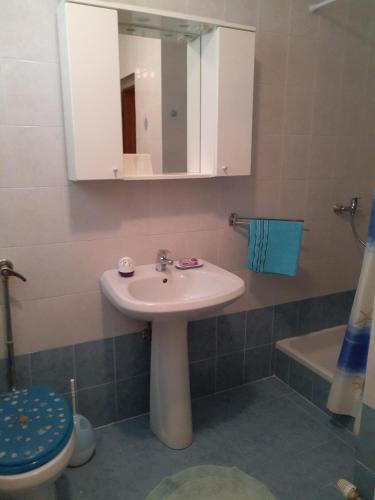 a bathroom with a sink and a toilet and a mirror at Lavanda in Mali Lošinj