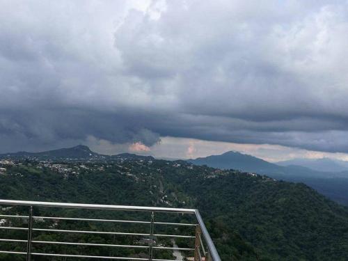 a view of a mountain range with clouds and trees at AAA Condominium in Tagaytay