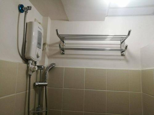 a shower in a bathroom with a tiled wall at AAA Condominium in Tagaytay