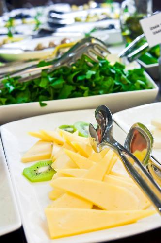 a white plate of food with cheese and kiwis at Marigold Thermal & Spa Hotel Bursa in Bursa
