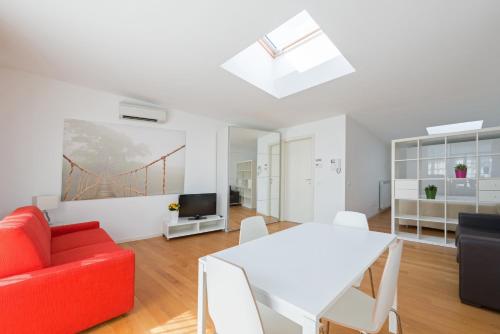 a living room with a red couch and a white table at La Maison del Capestrano in Milan