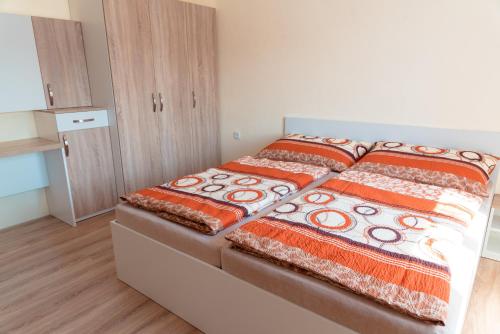 um quarto com 2 camas com colchas laranja e branca em Nad Šťastným sklepem em Valtice