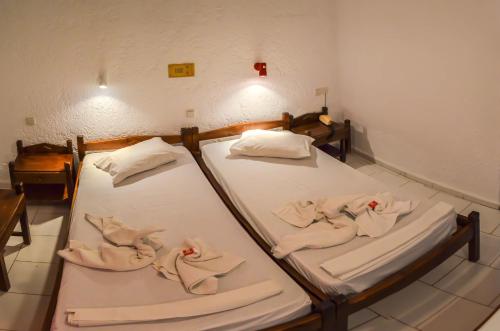 2 łóżka pojedyncze w pokoju z ręcznikami w obiekcie Sunlight Hotel w mieście Agia Galini