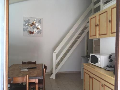 une cuisine avec une table à manger et un escalier dans l'établissement Lavu Santu, à Sainte-Lucie de Porto-Vecchio