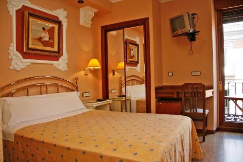 Postel nebo postele na pokoji v ubytování Hostal Victoria III