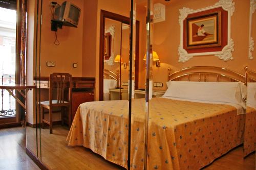 Postel nebo postele na pokoji v ubytování Hostal Victoria III