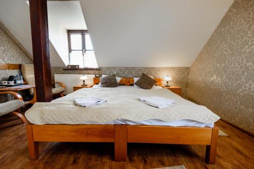 a bedroom with a bed with two towels on it at Pensjonat Pod Wietrzną Górą in Kazimierz Dolny