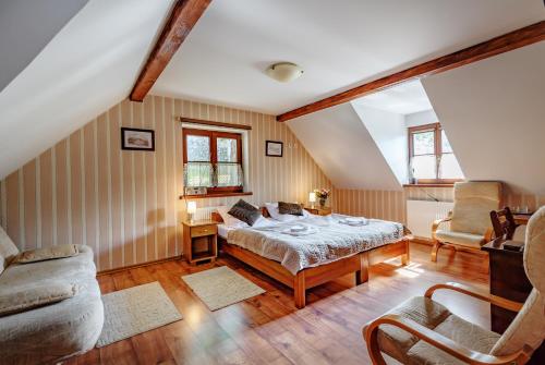 1 dormitorio con cama, sofá y sillas en Pensjonat Pod Wietrzną Górą, en Kazimierz Dolny