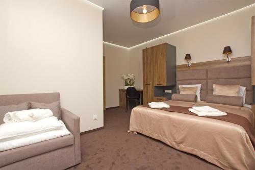 a hotel room with two beds and a couch at Ośrodek Promenada- Horyzont in Jastrzębia Góra