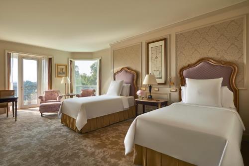 a large hotel room with two beds and a window at Four Seasons Cairo At The First Residence in Cairo