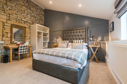 a bedroom with a large bed and a stone wall at Forest in Burnley