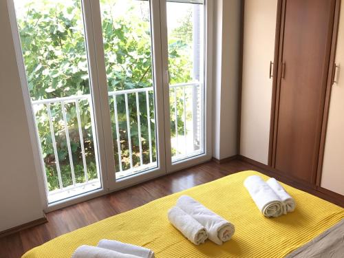 a room with two towels on a bed in front of a window at Apartmani Marija Klimno B in Klimno